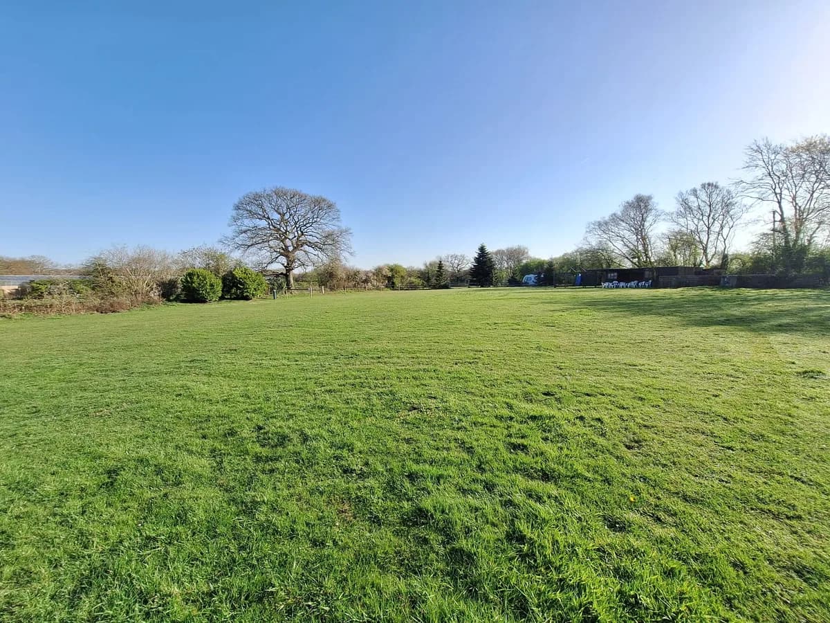 Wide open grass camping field with blue skies